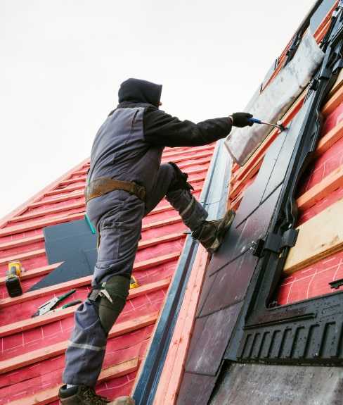 Man installing roof shingles.